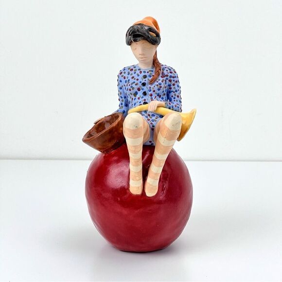 CARRIANNE L HENDRICKSON woman with beak hat sitting on apple sculpture 2… - Picture 2 of 16